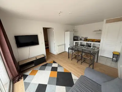 a living room with a television and a dining room at Appartement indépendant climatisé Chez Amel & Rémi in Fabrezan