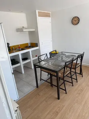 a dining room with a glass table and chairs at Appartement indépendant climatisé Chez Amel & Rémi in Fabrezan