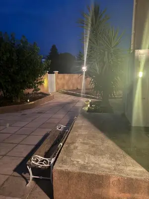 a bench sitting on the side of a sidewalk at night at Appartement indépendant climatisé Chez Amel & Rémi in Fabrezan