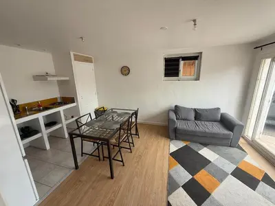 a living room with a table and a couch at Appartement indépendant climatisé Chez Amel & Rémi in Fabrezan