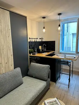 a living room with a couch and a kitchen at Beautiful Modern Studio in Carcassonne
