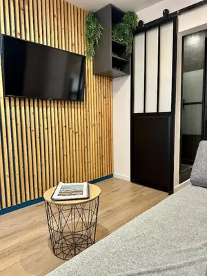 a living room with a flat screen tv on a wall at Beautiful Modern Studio in Carcassonne