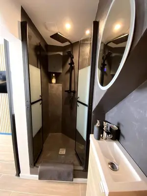 a bathroom with a shower with a sink and a mirror at Beautiful Modern Studio in Carcassonne