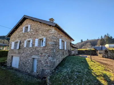a stone house in the middle of a yard at La Bergerie Maison familiale in La Salvetat