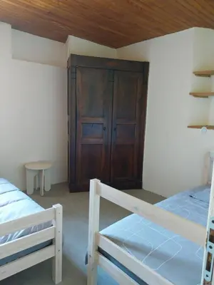 a bedroom with two bunk beds and a wooden door at La Bergerie Maison familiale in La Salvetat