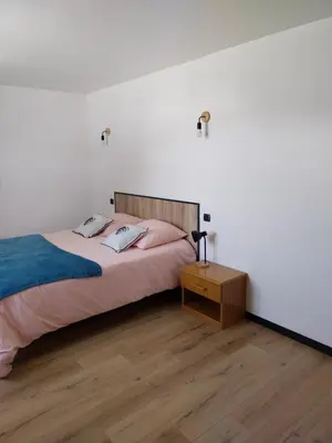 a bedroom with a bed and a wooden floor at La Bergerie Maison familiale in La Salvetat