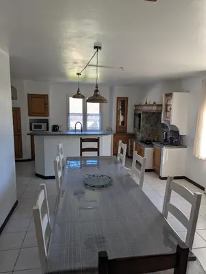 a dining room and kitchen with a table and chairs at La Bergerie Maison familiale in La Salvetat