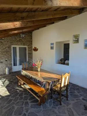 a large wooden table in a room with two chairs at La Bergerie Maison familiale in La Salvetat