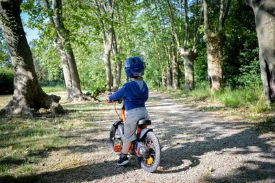 a young child riding a bike down a dirt road at La Résidence du Château de Jouarres in Azille