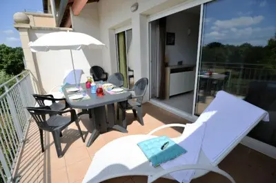 a patio with a table and chairs and an umbrella at La Résidence du Château de Jouarres in Azille