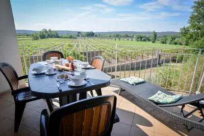 a table and chairs on a balcony with a view at La Résidence du Château de Jouarres in Azille