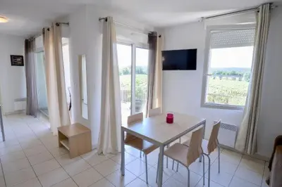 a dining room with a table and chairs and a window at La Résidence du Château de Jouarres in Azille