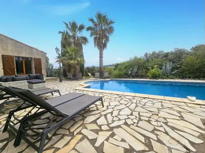 a patio with a table and chairs next to a swimming pool at La Cerisette in Félines-Minervois