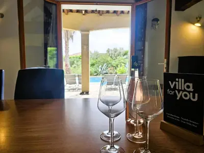 two wine glasses sitting on a table with a bottle of wine at La Cerisette in Félines-Minervois