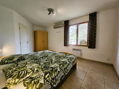 a bedroom with a bed and a window at La Cerisette in Félines-Minervois