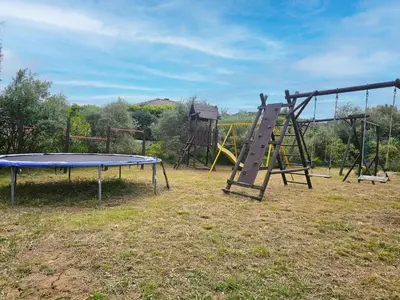 an empty playground with a slide and a monkey bar at La Cerisette in Félines-Minervois