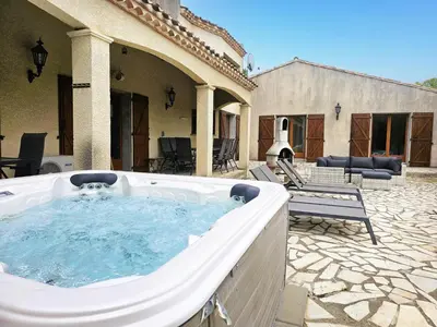 a large hot tub in a yard with a patio at La Cerisette in Félines-Minervois