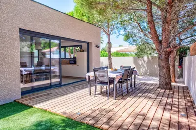 a patio with a table and chairs on a wooden deck at Villa Louise in Lapalme