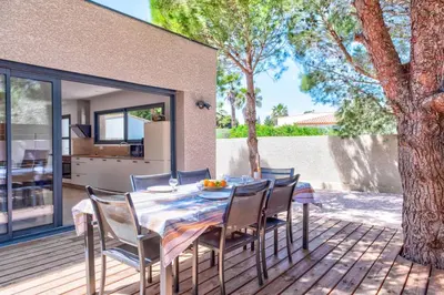 a table and chairs on a deck with a house at Villa Louise in Lapalme