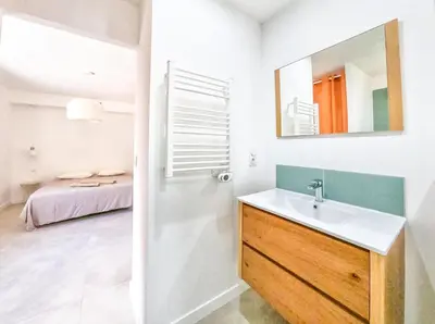 a bathroom with a sink and a mirror and a bed at Villa Louise in Lapalme