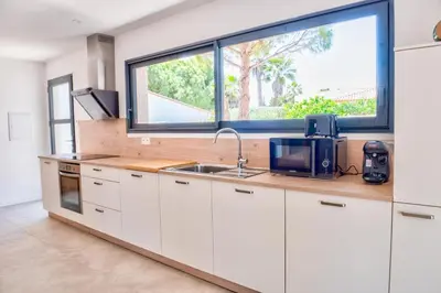 a kitchen with a sink and a large window at Villa Louise in Lapalme