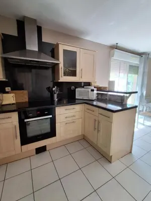 a kitchen with wooden cabinets and a black counter top at Family villa in Salles-d'Aude in Salles-dʼAude