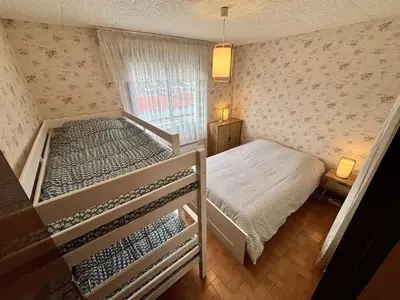 a bedroom with two bunk beds and a window at Appartement 2 pièces - Port la Nouvelle PN010-18 in Port-la-Nouvelle