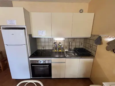 a small kitchen with a sink and a refrigerator at Appartement 2 pièces - Port la Nouvelle PN010-18 in Port-la-Nouvelle