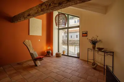 a living room with a chair and a large window at Ostal de la placette in Padern