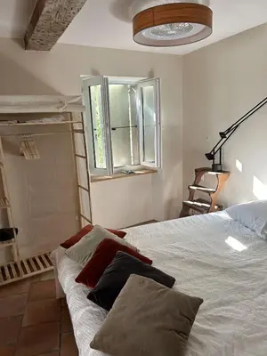 a bedroom with a bed and a window at Ostal de la placette in Padern