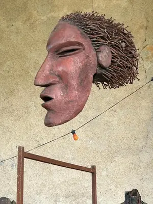 a statue of a head on a wire at Ostal de la placette in Padern