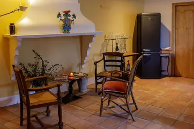 a kitchen with a table and chairs and a refrigerator at Ostal de la placette in Padern