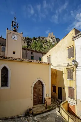 a building with a clock tower on top of it at Ostal de la placette in Padern