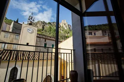 a view from a window of a building with a clock tower at Ostal de la placette in Padern