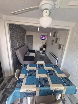 a room with a table and a living room at Apartment T2 Gruissan in Gruissan