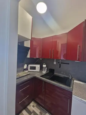 a kitchen with red cabinets and a sink at Apartment T2 Gruissan in Gruissan