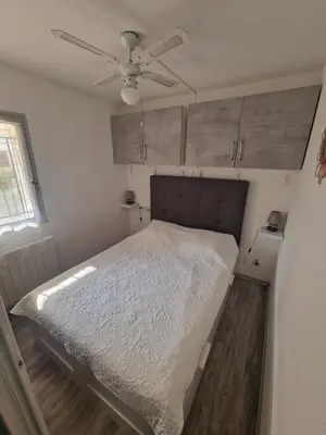 a bedroom with a bed and a ceiling fan at Apartment T2 Gruissan in Gruissan