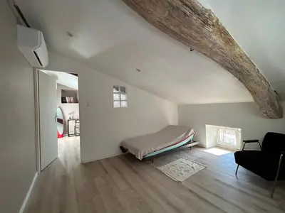 a bedroom with a bed in a white room at Maison chaleureuse atypique in Saint-Chinian