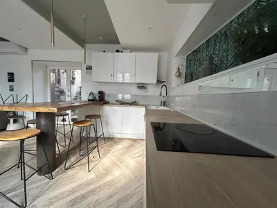 a kitchen with white cabinets and a wooden counter top at Maison chaleureuse atypique in Saint-Chinian