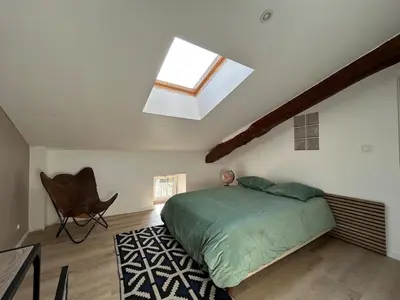 a bedroom with a bed and a skylight at Maison chaleureuse atypique in Saint-Chinian
