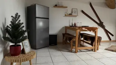 a kitchen with a refrigerator and a table with a christmas tree at Appartement style chalet proche Cité Carcassonne & lac de la Cavayère in Trèbes