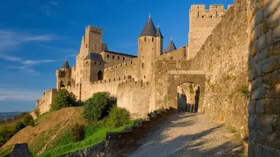 an old castle on a hill with an archway at Appartement style chalet proche Cité Carcassonne & lac de la Cavayère in Trèbes