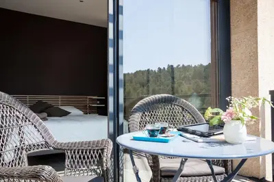 a patio with a table with a laptop on it at Gîte au cœur des vignes, vue sur le Minervois in Bize-Minervois