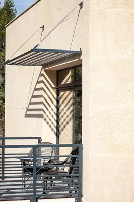 a bench sitting on a porch with an umbrella at Gîte au cœur des vignes, vue sur le Minervois in Bize-Minervois