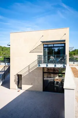 a house with a staircase on the side of it at Gîte au cœur des vignes, vue sur le Minervois in Bize-Minervois