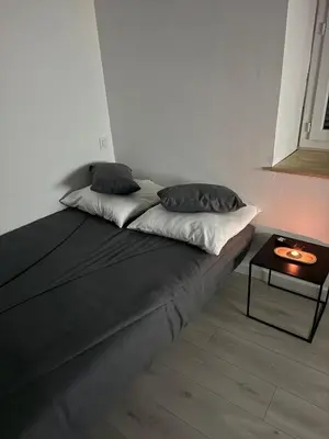 a bed with two pillows and a table in a room at La perle centrale - Studio in Limoux