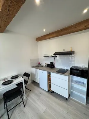 a kitchen with white cabinets and a counter top at La perle centrale - Studio in Limoux