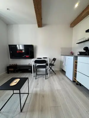 a living room with a table and a kitchen at La perle centrale - Studio in Limoux