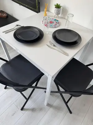 a white table with black chairs and plates on it at La perle centrale - Studio in Limoux
