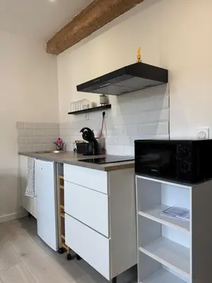 a kitchen with a counter and a stove top oven at La perle centrale - Studio in Limoux
